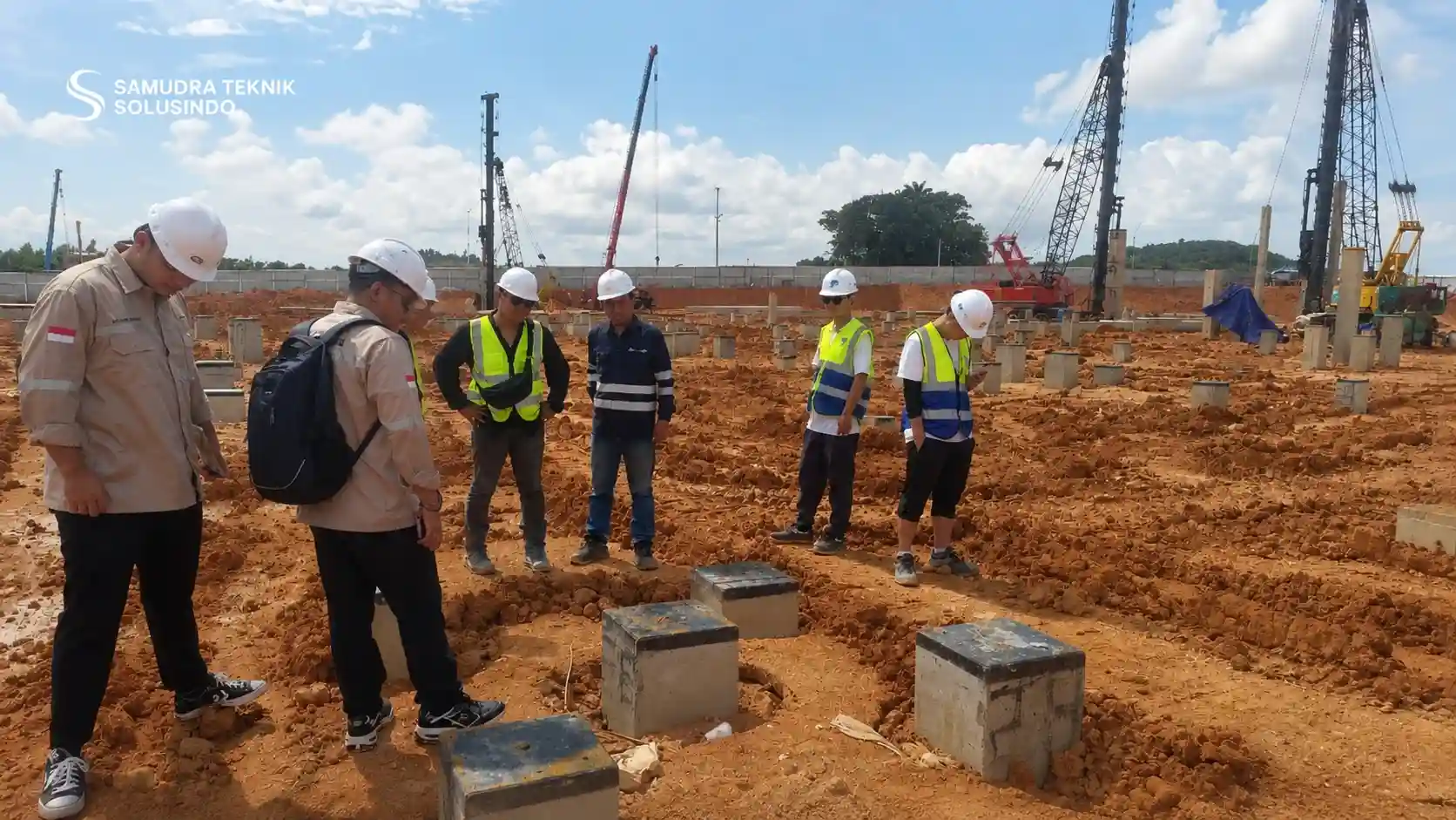 Teknisi menggunakan APD lengkap saat melakukan uji pondasi di lapangan